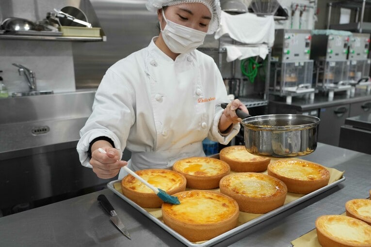 焼き上がったチーズケーキの表面にアプリコットジャムが塗られていく