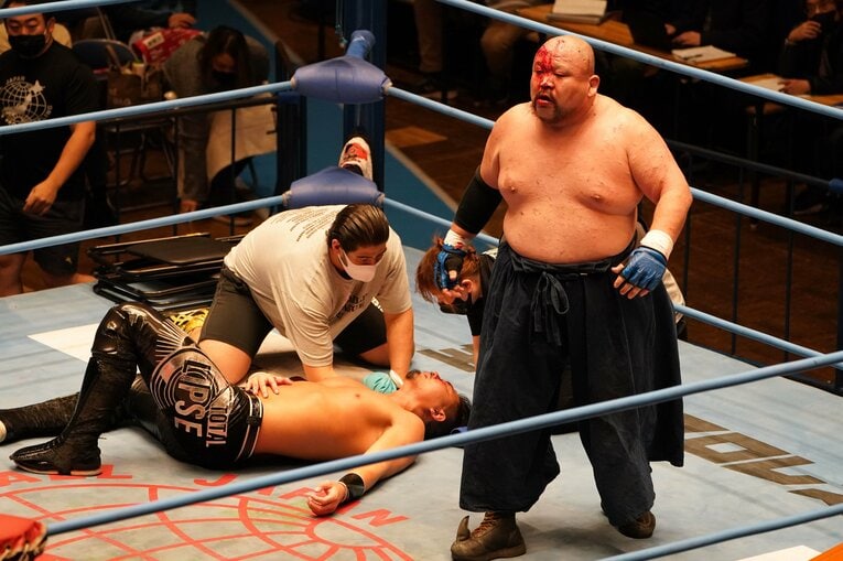 試合に敗れて大の字になるジェイク・リーと、勝ち名乗りをあげるアブドーラ・小林（写真をクリックすると「この記事の写真」に飛びます。過激な写真を含みますのでご注意ください）