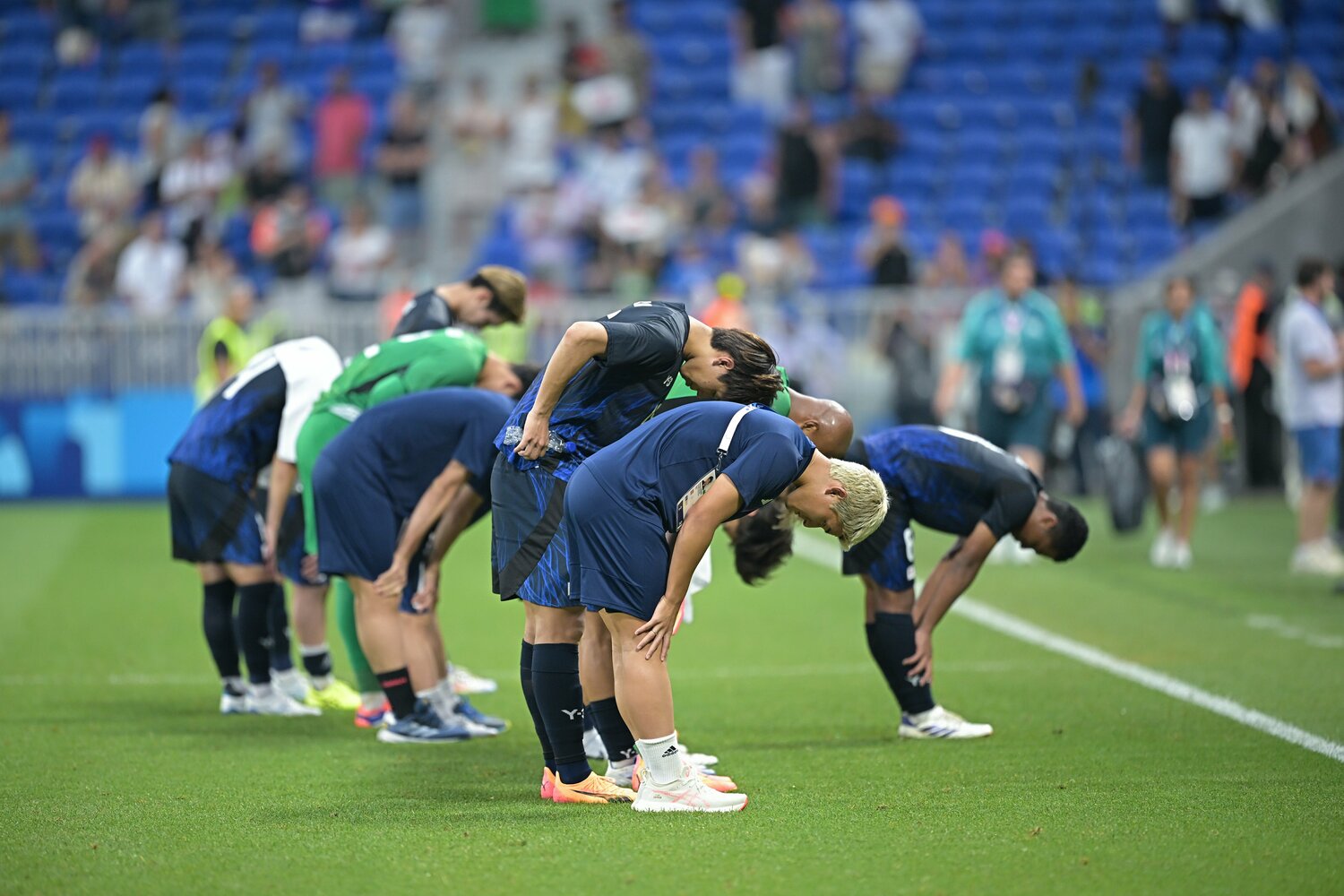 パリ五輪での戦いを終え、ピッチで深々と礼をするU-23日本代表　©Takuya Kaneko/JMPA