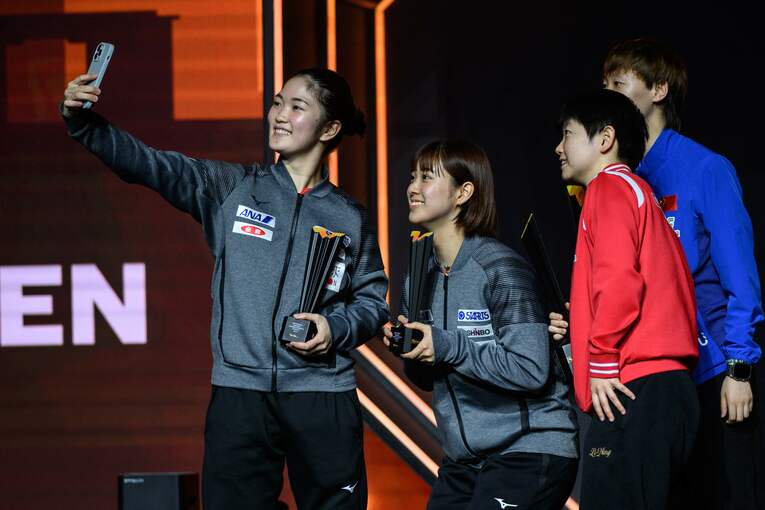 ダブルスではペアとしてもプレーする木原美悠と長崎美柚。中国選手らと記念撮影　©JIJI PRESS