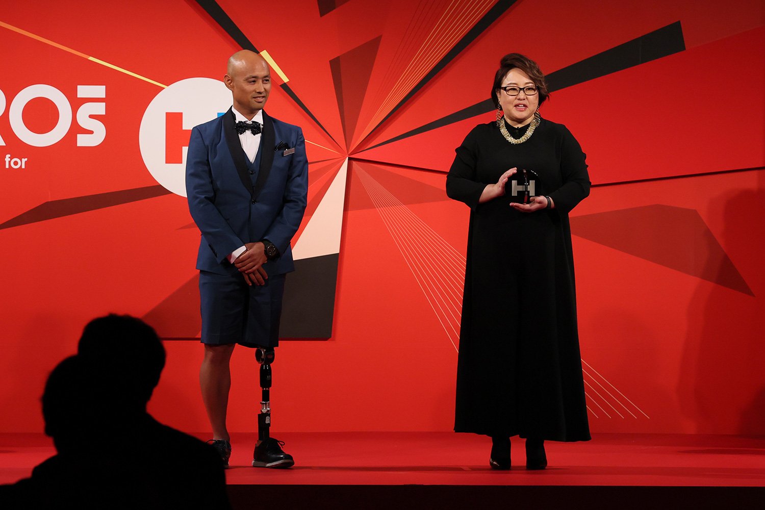 パラリンピックメダリストの山本篤さん（左）から、トロフィーを受け取ったオットーボック・ジャパンの深谷香奈さん