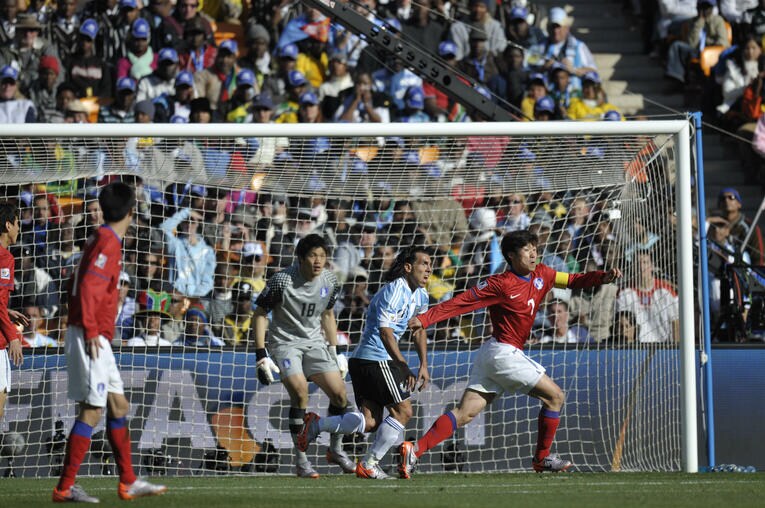 チョン・ソンリョンとカルロス・テベス、パク・チソンによるゴール前の攻防　©Takuya Sugiyama/JMPA