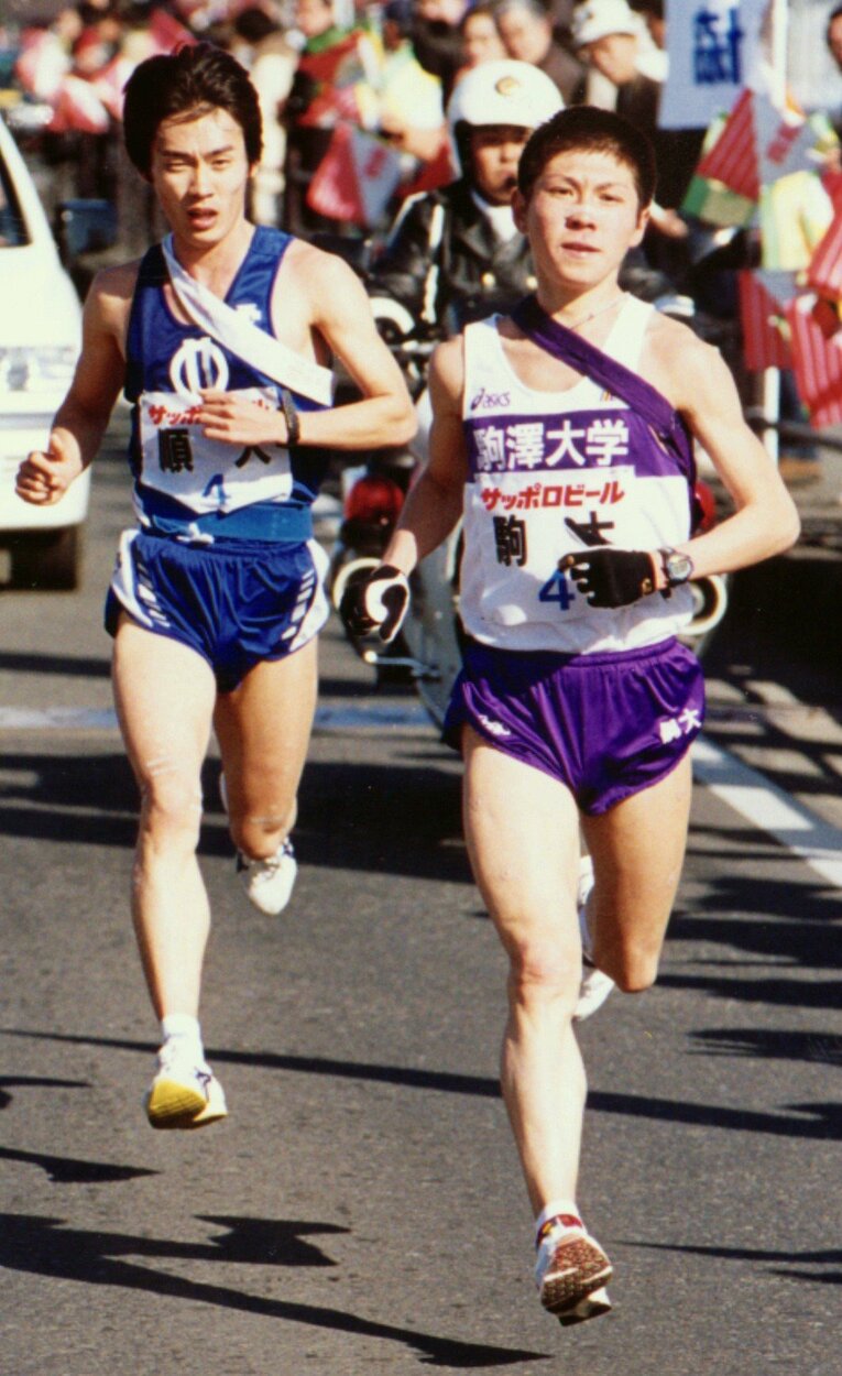 大八木監督の後任に指名された藤田敦史・現ヘッドコーチ。写真は1999年の箱根駅伝。4区を走った藤田（右）は区間新をマークした　©Sankei Shimbun