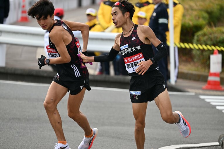 8区を走った2年生の鎌田匠馬から襷を受けた吉田（左）。182cmの長身ランナーだ　©Naoya Sanuki