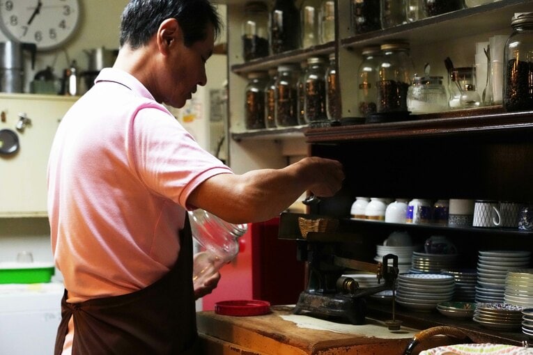 グラインダーにかける前に豆の重さをはかる林さん　©Essei Hara