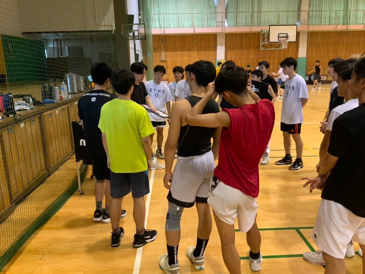 都島工業高でバスケ部監督を務める29歳の下村（中央）／学校提供