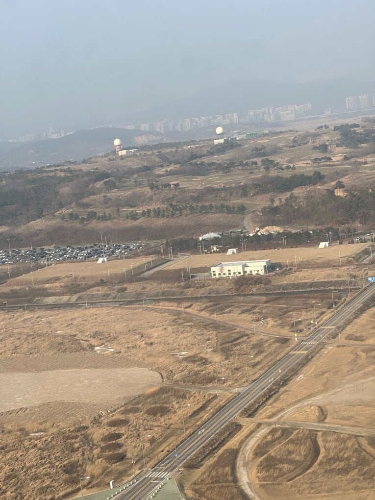 飛行機着陸時の写真。遠くの街が黄砂でかすんでいる