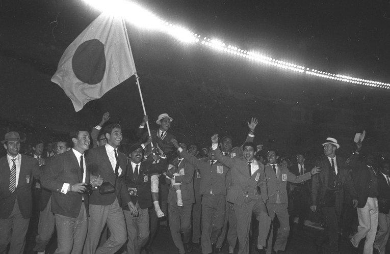 日本の旗手（競泳の福井誠）を肩車し、そのまま競技場を一周してしまった各国の選手団。1964年の閉会式は半ばカオスと化していた　©AFLO