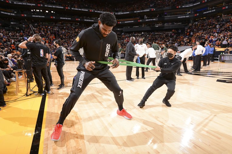 ディアンドレ・エイトンのウォームアップをサポートする玉川さん　©︎Phoenix Suns Social Media 