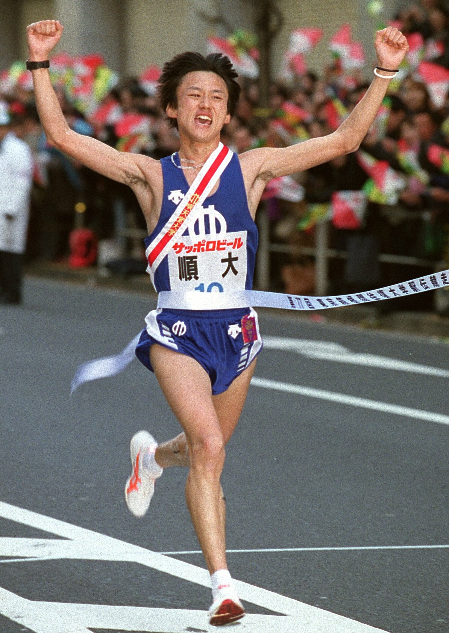 紫紺対決を制し、順大の学生駅伝3冠の達成となるゴールテープを切った宮崎　©JIJI PRESS