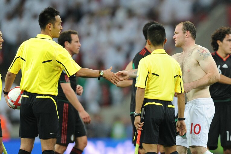 2010年、試合後にイングランド代表FWウェイン・ルーニーと握手をかわす家本　©︎AFLO