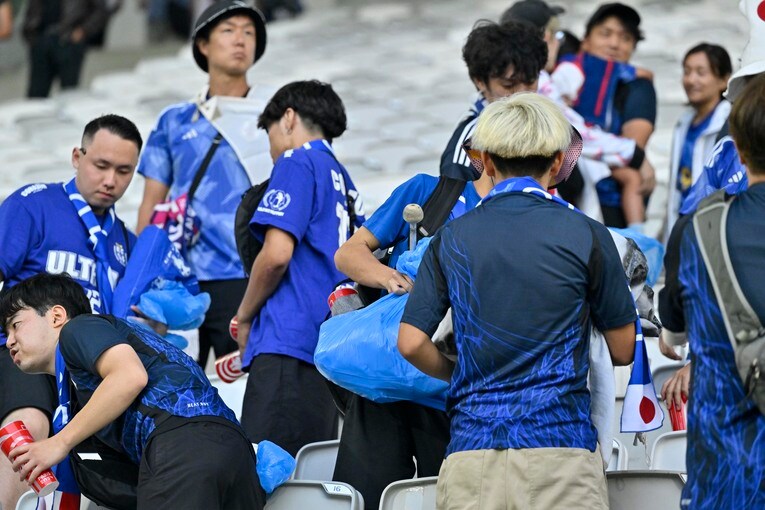 ゴミ拾いする日本サポーター　©Takuya Nakachi/JMPA