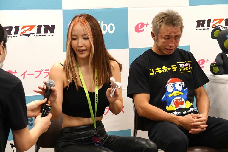 満身創痍の久保優太と、マイクを受け取る元妻のサラ　©Koji Fuse