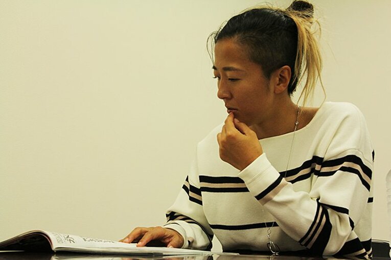 当時の『サッカーダイジェスト』を興味深そうに読む永里©Atsushi Iio