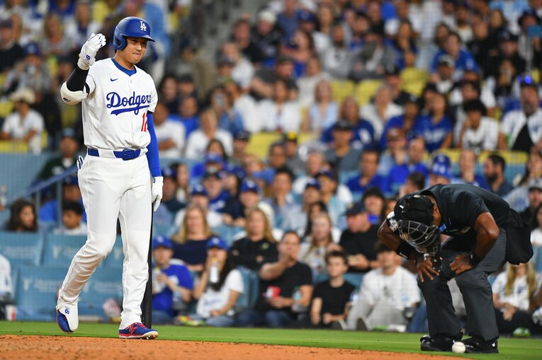 自身の放ったファウルが当たった球審を心配する大谷。この直後に30号本塁打が　©Getty Images