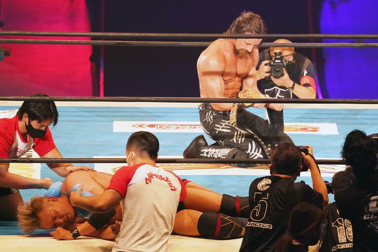 リング上に横たわるオカダ・カズチカとIWGP世界ヘビー級のベルトを手にしたジェイ・ホワイト