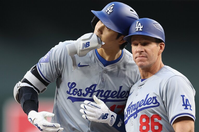 一塁コーチのクレイトン・マッカローと、仲良く「ヘッド・バンプ」をする大谷翔平 ／ photograph by Getty Images