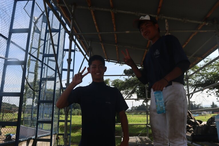 後輩と笑顔を見せる山本龍治キャプテン（3年・写真左）