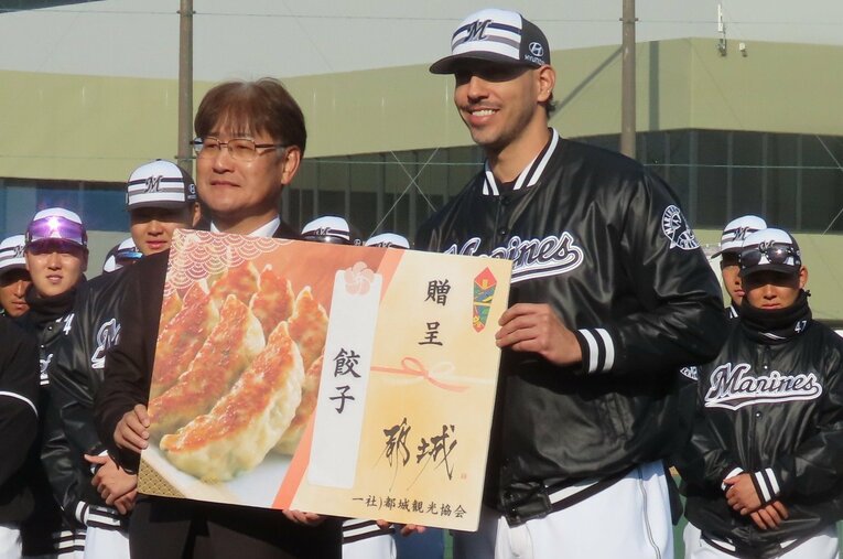 【テレビに映らないロッテキャンプ初日写真】餃子贈呈にニコニコのロッテ新主将ソト（写真は右へ続きます）　©Kou Hiroo