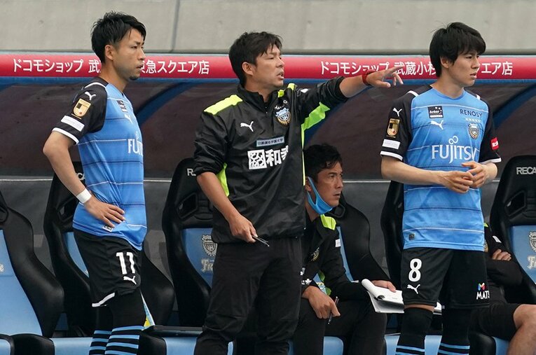 ベンチで小林悠（左）と脇坂泰斗（右）に指示を出す鬼木監督。選手交代は「感覚的なところでいつも決めている」と語る ／ photograph by Getty Images