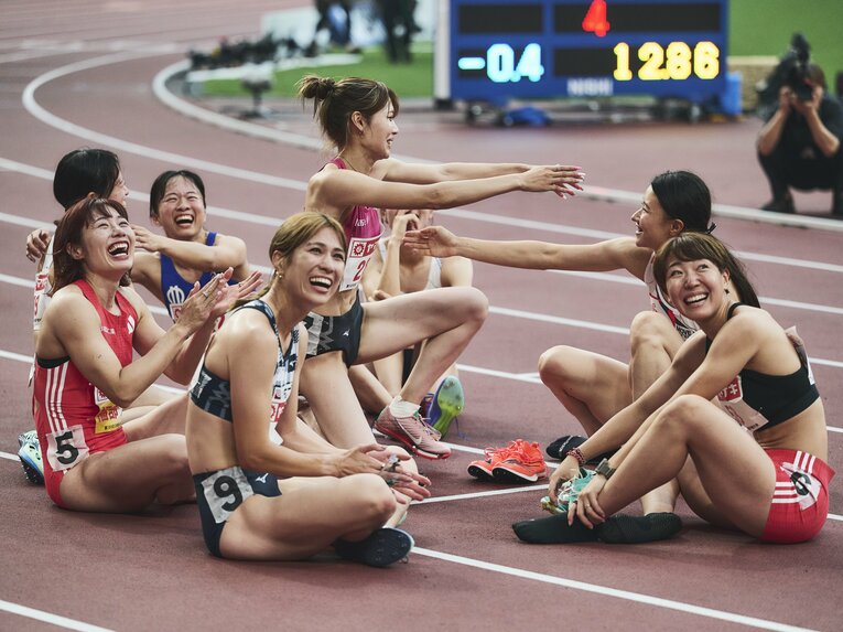 8人で車座になって結果の確定を待つ選手たち　©Yuki Suenaga