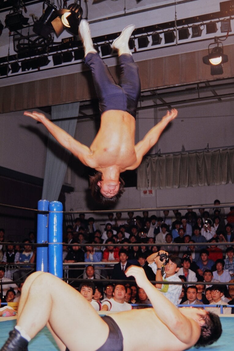 新日本プロレスに凱旋帰国した第1戦、藤波辰巳（辰爾）にムーンサルトプレスを見舞う武藤敬司（1986年10月13日）©︎Yukio Hiraku/AFLO