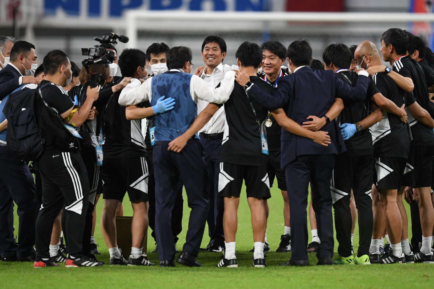 E-1選手権優勝後、笑顔でスタッフたちと円陣を組む森保一監督　©Masashi Hara/Getty Images