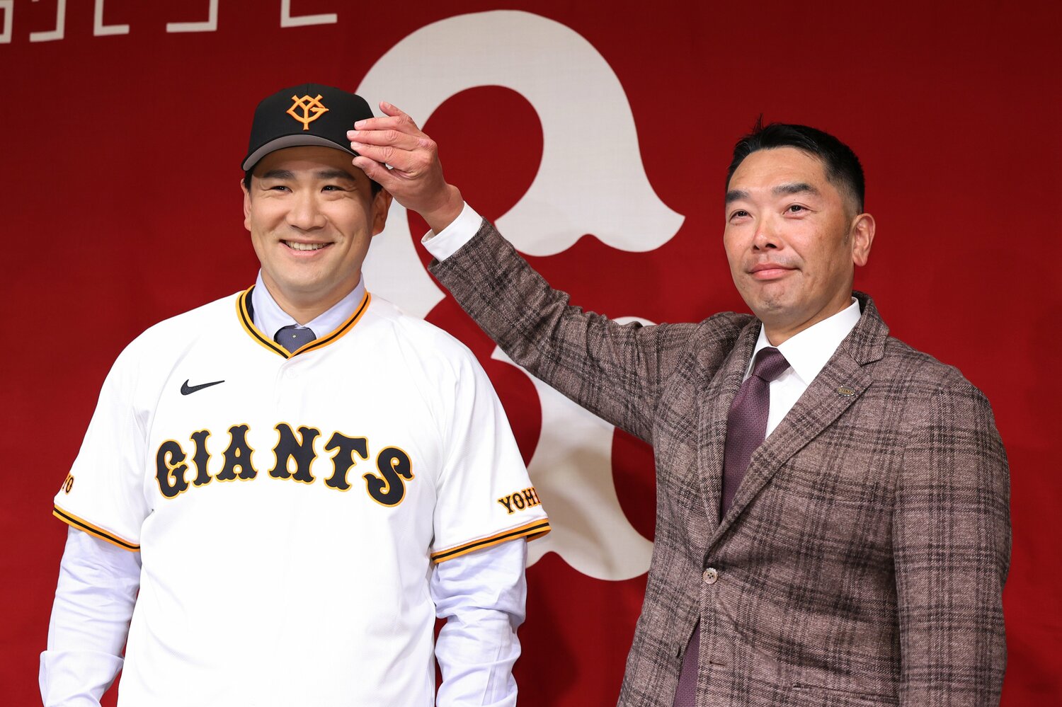 巨人に入団が決まった田中将大の帽子に手を差し伸べる阿部慎之助監督　©︎JIJI PRESS