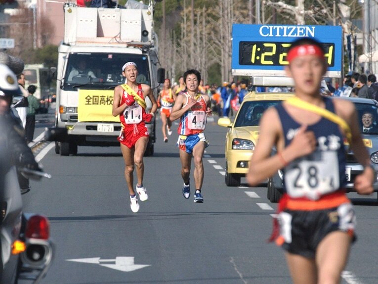 2002年の全国高校駅伝。4区でトップの西脇工を懸命に追走、区間最高記録をマークした佐賀県立白石高校の高井和治（左）　©KYODO