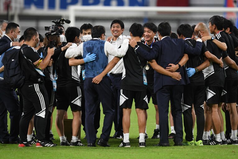 E-1選手権優勝後、笑顔でスタッフたちと円陣を組む森保一監督　©Masashi Hara/Getty Images