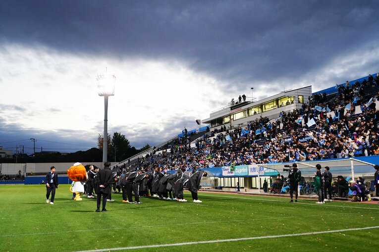 ニッパツ三ツ沢球技場に集ったサポーターに頭を下げる横浜FCの選手たち　©Etsuo Hara/Getty Images