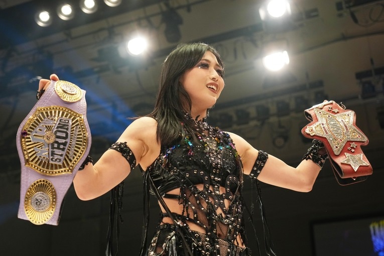 STRONG女子王座のベルトと赤いベルトを誇示する上谷沙弥　©Essei Hara