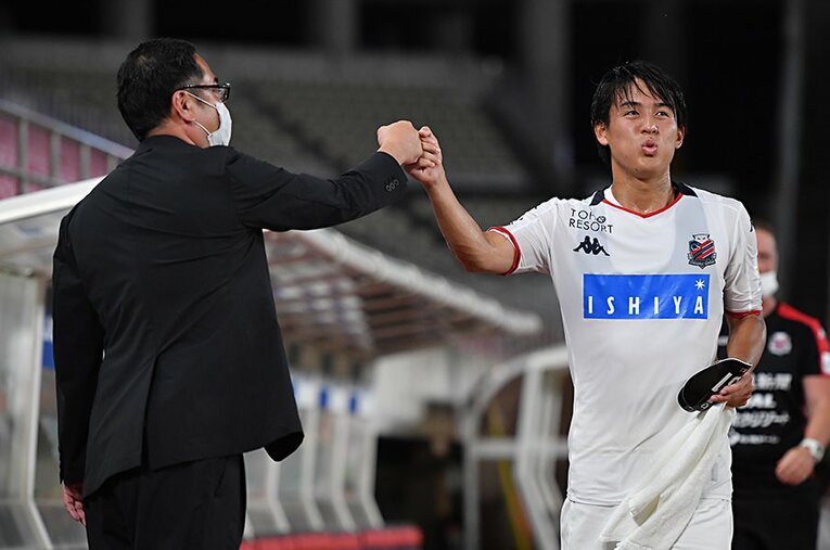 鹿島戦後、札幌の竹林強化部長と喜びを分かち合うMF高嶺。 ／ photograph by J.LEAGUE