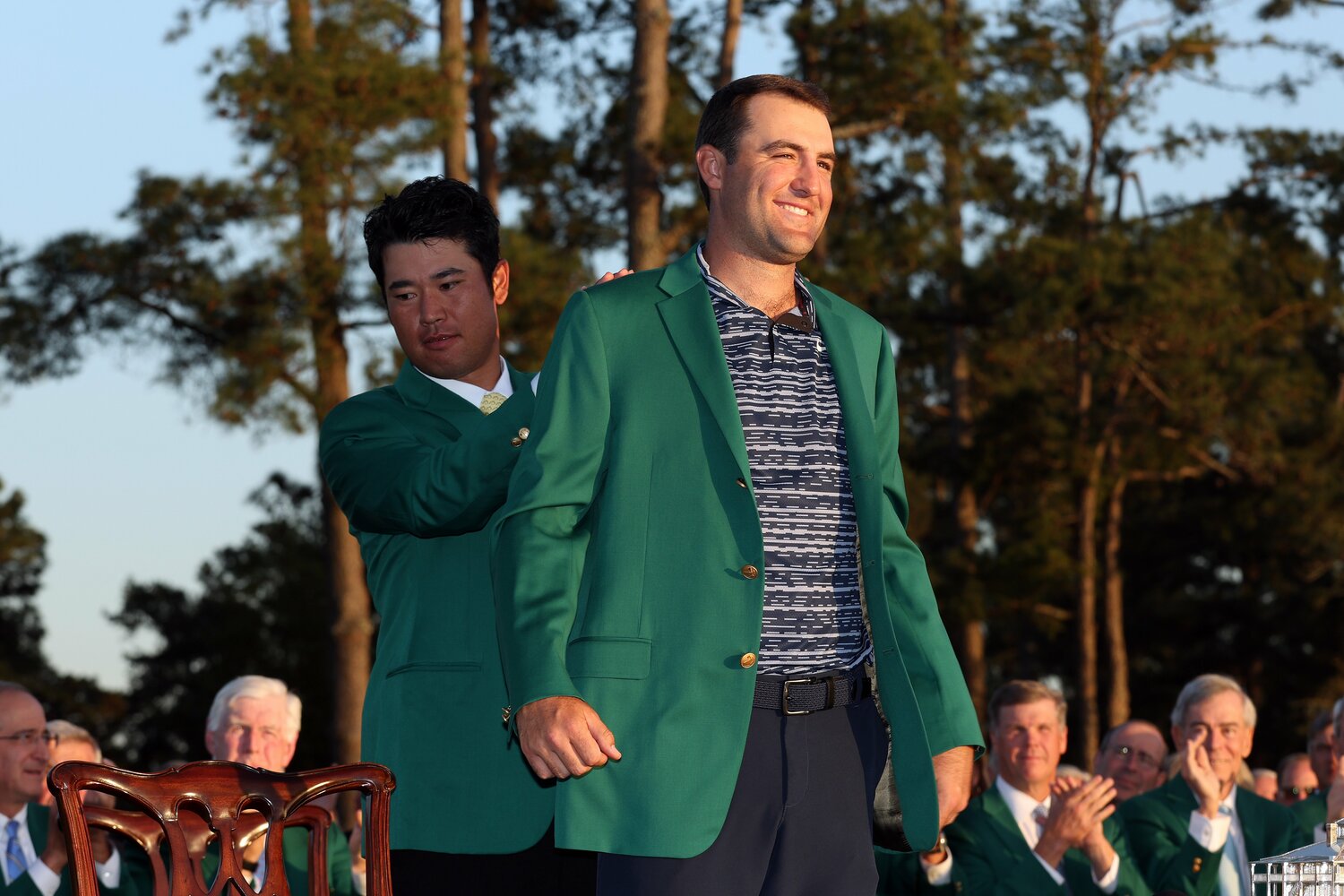 今年4月に2度目のマスターズ制覇を達成したスコッティ・シェフラー。初優勝した2022年には、前年度王者の松山英樹（左）からグリーンジャケットを受け取ったが、まさかその2年後に囚人服を着せられるとは…　©︎Getty Images