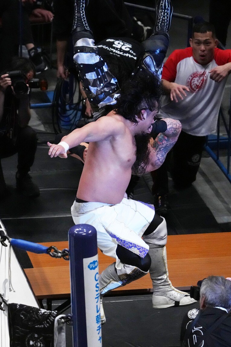 コーナーからデビッド・フィンレーを場外のテーブルに叩きつける後藤洋央紀　©Essei Hara