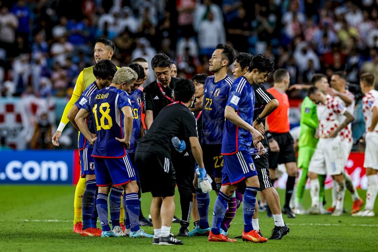 PK戦前、アシスタントコーチが示すタブレットを注視する選手たち。森保監督の姿はここには見えないようだ　©Kiichi Matsumoto/JMPA