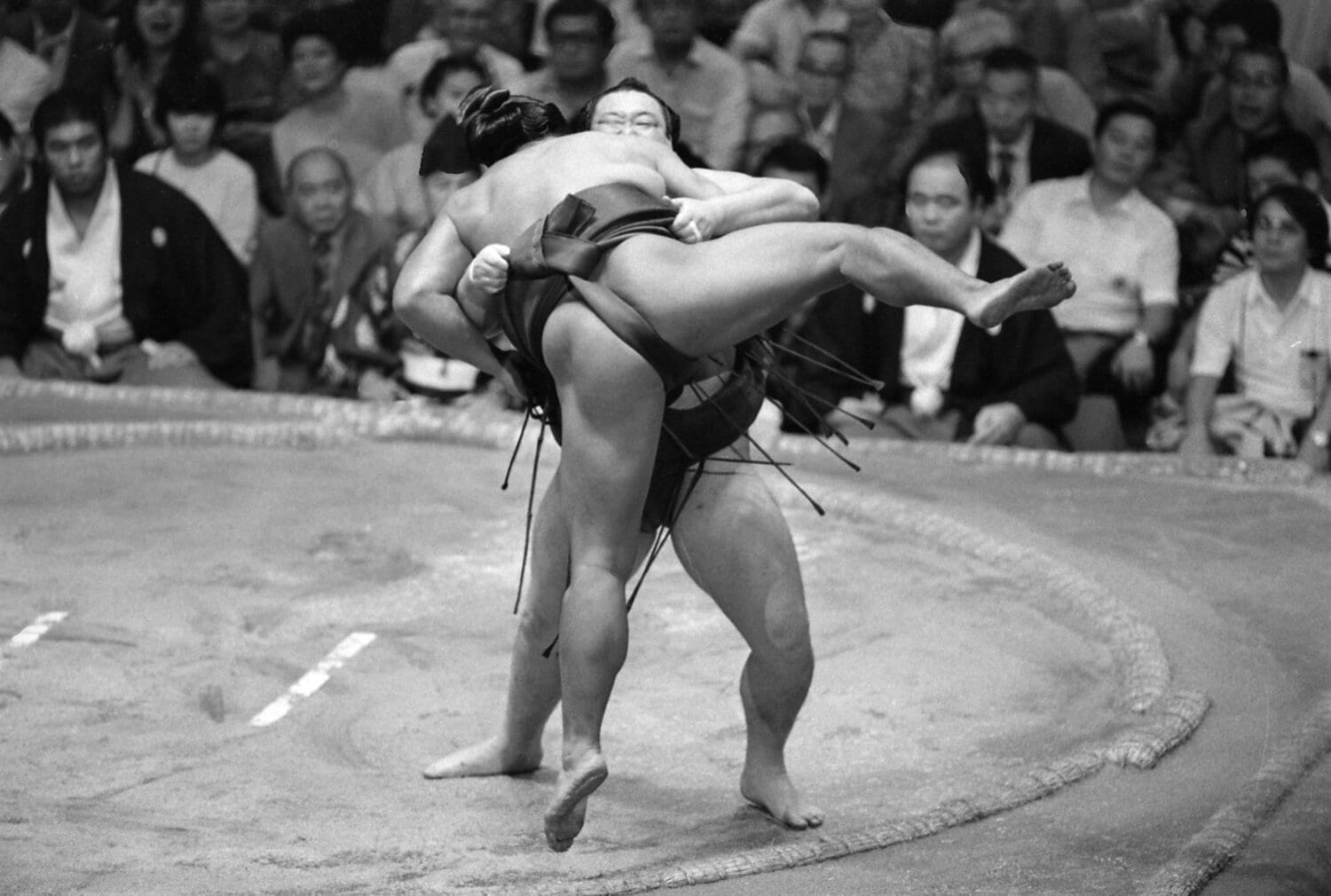 写真は1983年の秋場所（9月場所）。隆の里と千代の富士が千秋楽に全勝対決。新横綱の隆の里（奥）が千代の富士をつり出して優勝を決めた　©JIJI PRESS
