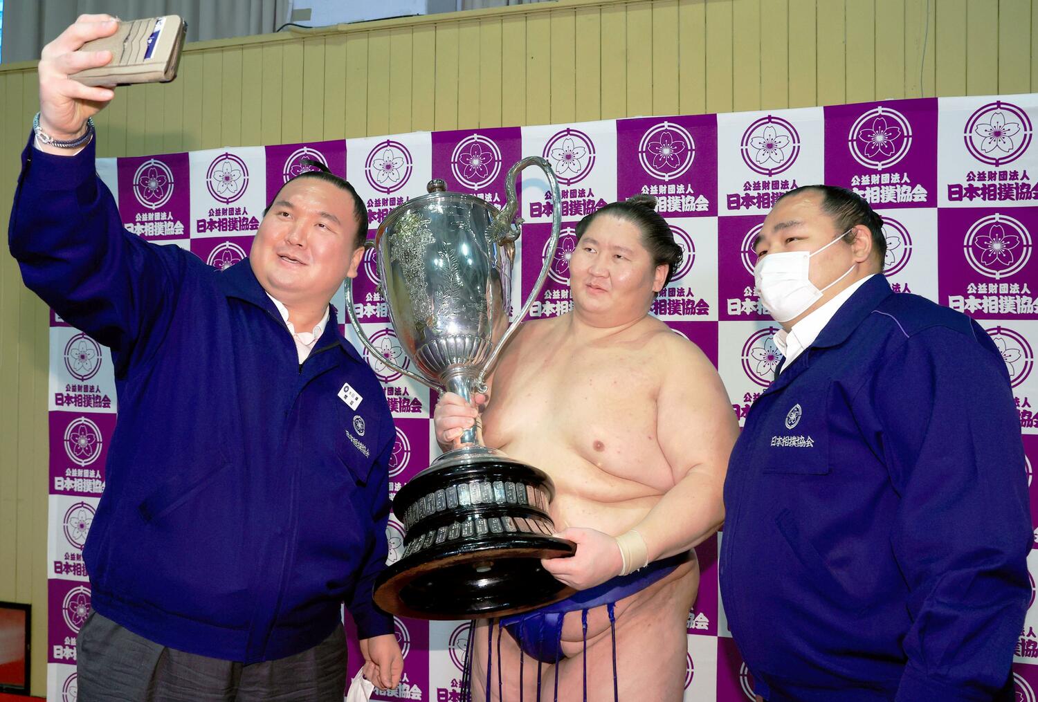 初優勝を果たし、間垣親方（元白鵬、左）、鶴竜親方（右）とスマートフォンで記念撮影する逸ノ城　©KYODO