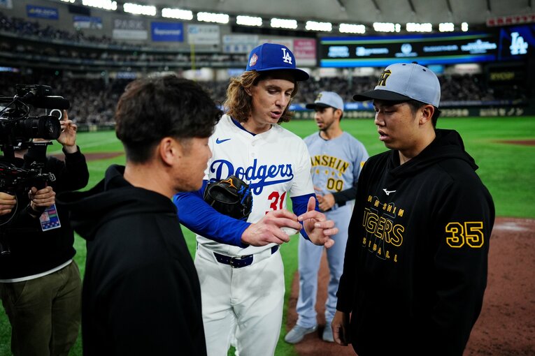 【マケイン記者が驚いた阪神・才木浩人】ドジャース戦後、タイラー・グラスノーにカーブボールの握り方を教えてもらう才木浩人。ピッチング談義は約2分間続いた　©Getty Images