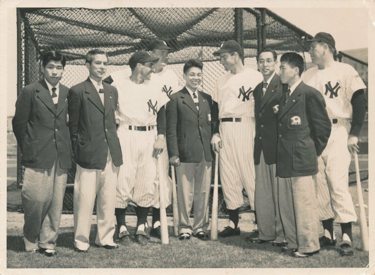 ジョー・ディマジオ（右から4人目）らヤンキースの選手たちと写真に収まるボストンマラソンの日本選手団。田中茂樹は写真中央（本人提供）