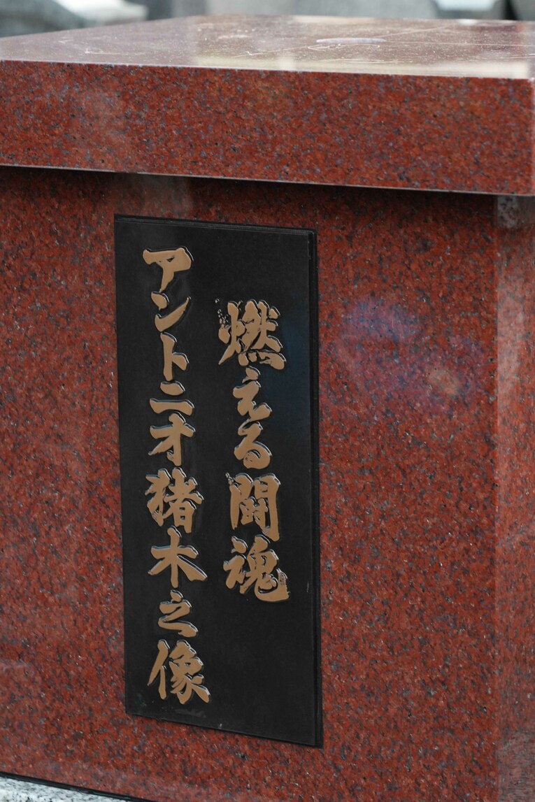 赤御影石の台座には「燃える闘魂　アントニオ猪木之像」とある。書家・森大衛さんによるもの