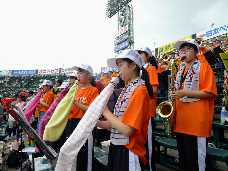 雨や日差しから楽器を守るため、タオルで巻いて応援する敦賀気比高校吹奏楽部（2018年撮影）