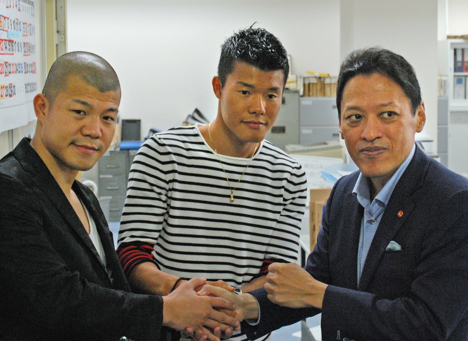 2016年、亀田家の三男・和毅(中央)が再び協栄ジムに所属することが決まり、握手する長兄・興毅と金平会長 ©︎JIJI PRESS