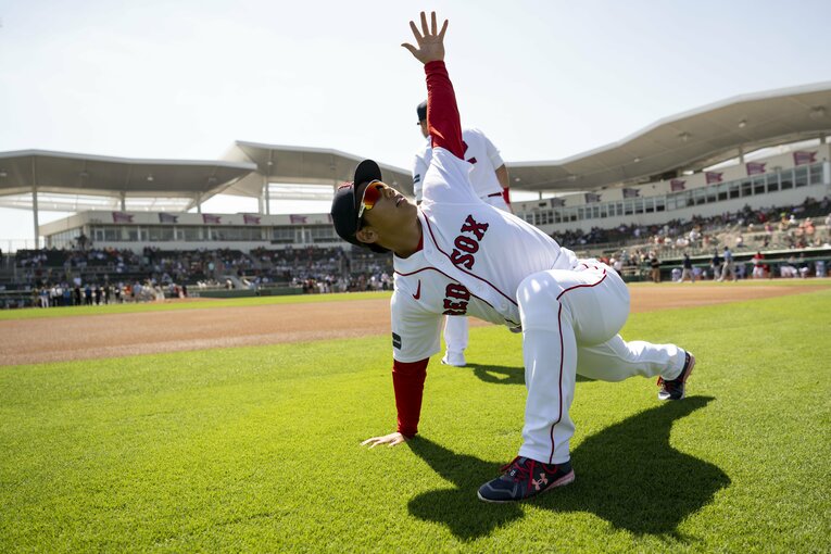 ウォーミングアップで身体を伸ばす吉田正尚　©︎Getty Images