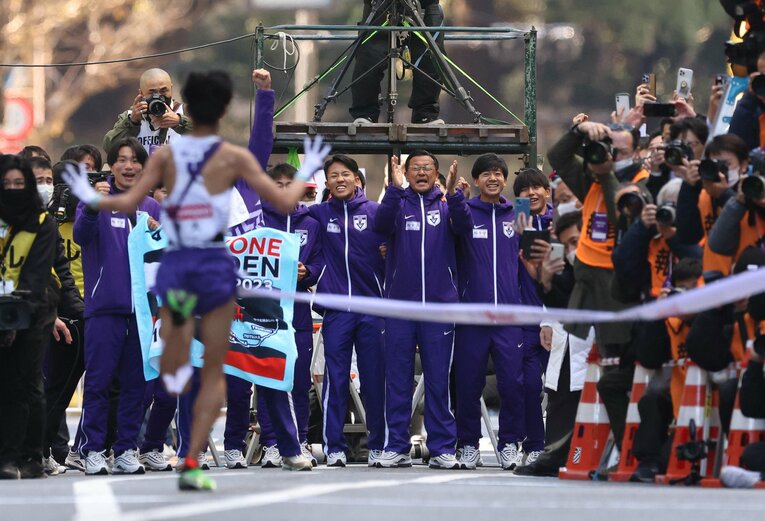 ゴールを選手たちに囲まれながら待つ大八木監督　©JIJI PRESS