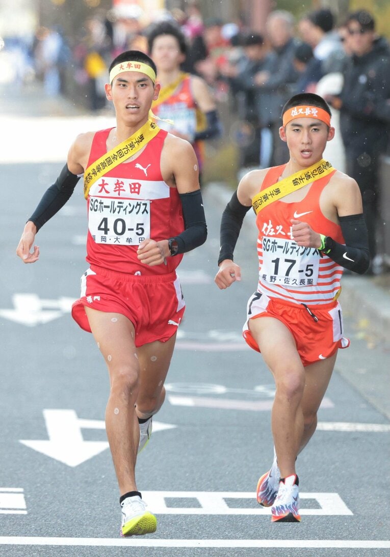 都大路の5区、佐久長聖の酒井崇史（右）と競り合う塚田虎翼（大牟田）　©JIJI PRESS