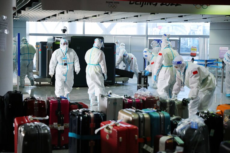 防護服姿で作業をする空港の職員たち　©JMPA