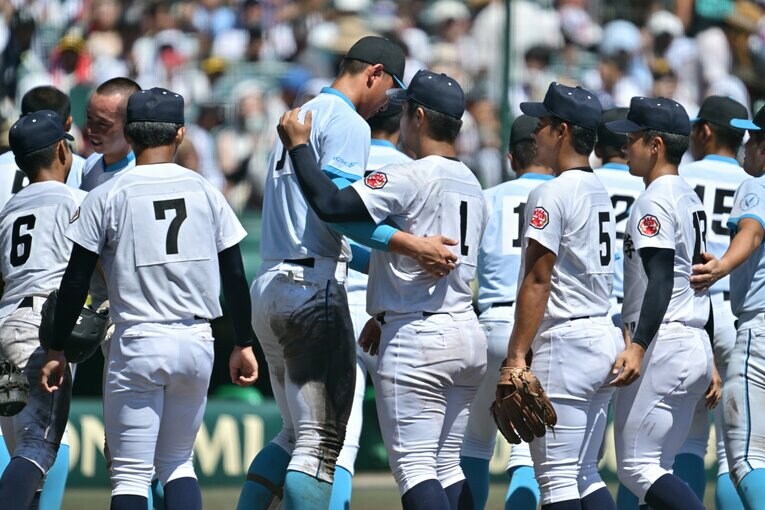 山梨学院の2年生・菰田陽生と抱き合い、言葉をかわす末吉良丞　©Hideki Sugiyama