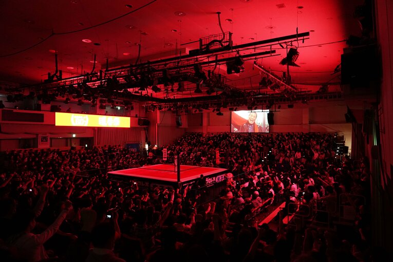 スクリーンに映るアントニオ猪木の「ダァーッ」に合わせて拳を突き上げる観客たち