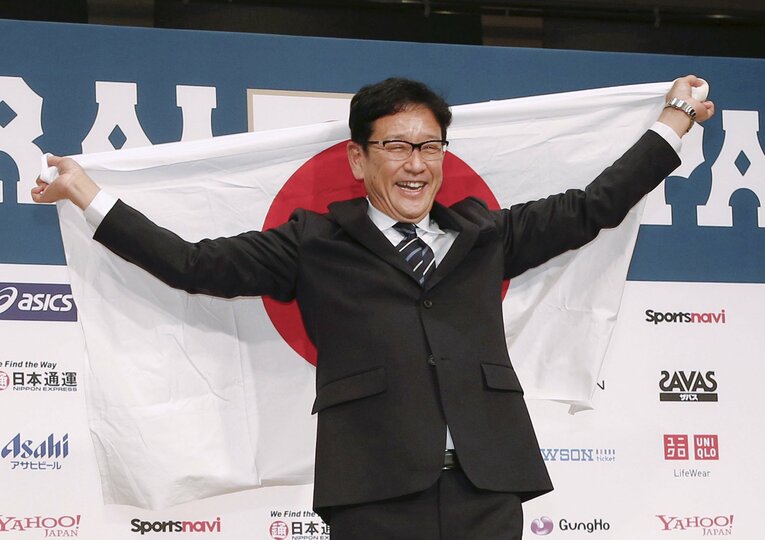 侍ジャパン監督就任の会見で日の丸を広げる栗山英樹（2021年12月2日）©️KYODO